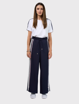 Navy and white wide leg pant with elastic waist, flat front, adjustable ties, and contrast tape detail on side seams.