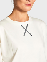 A model displays a fashionable outfit consisting of a white top and navy pants, highlighting a clean aesthetic.
