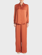A soft, copper-hued shirt laid flat, featuring a simple design suitable for everyday wear.