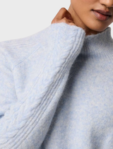 Blue Frost Savanna Alpaca Blend Sweater displayed on a hanger, showcasing its soft texture and elegant design.