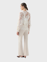 Antoinette LS blouse in cream, featuring long sleeves, elegantly presented on a hanger for display.
