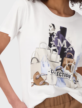  A model displays a cream round neck T-shirt adorned with a cat image.