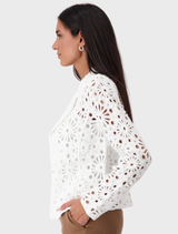 A cream-colored lapel knitted blazer hanging, highlighting its stylish cut and cozy fabric.