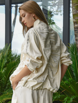 Modern cream jacket featuring a liquid-like shine, dual zipper, and adjustable drawstrings for personalized styling.