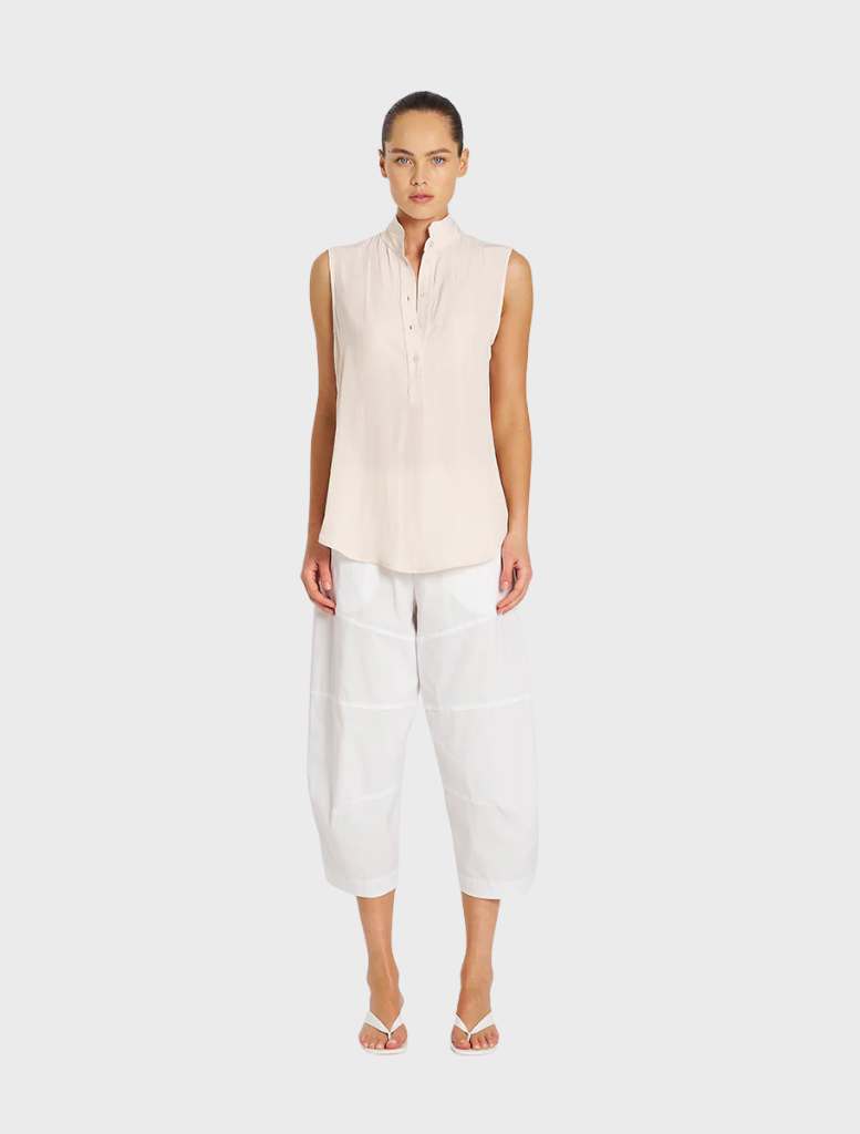 White cropped Tuscan pants displayed on a hanger, showcasing a sleek and modern design suitable for casual or formal wear.