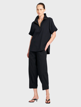 Black cross pants shown on a neutral backdrop, highlighting their stylish design and versatile use in fashion.