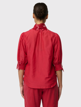 Jardin Cotton Silk Lace Blouse in Dahlia Red, characterized by embroidered embellishments and a loose fit with three-quarter length sleeves.