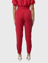 Dahlia red jogger pants tailored from a silky cupro-viscose blend, equipped with elasticated button cuffs and utility pockets.