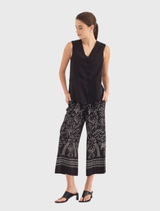 Lightweight black vest with a V neckline, button front, and jet pockets, designed for versatile warm-weather dressing.