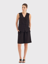 Black Darling Vest featuring a V neckline, curved button front, and functional jet pockets for a tailored, refined look.
