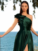 Elegant deep emerald gown hanging on a rack, highlighting its luxurious fabric and sophisticated style.