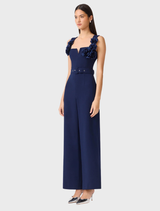 A deep navy sleeveless jumpsuit from Leonara, showcasing a modern silhouette with a fitted top and flowing wide legs.
