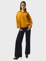 A woman dressed in dark blue wide leg jeans, showcasing a casual and stylish look.