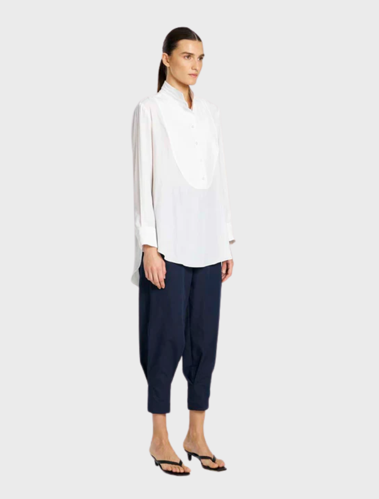 Classic white dinner shirt showcased on a hanger, designed with a traditional collar and long sleeves for formal wear.