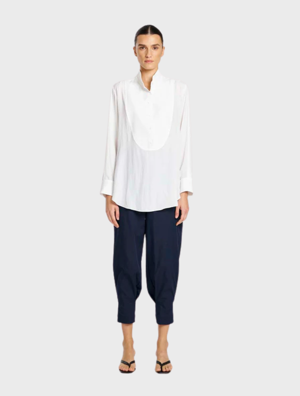 White dinner shirt displayed on a hanger, featuring a classic collar and long sleeves, suitable for formal occasions.