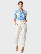 A woman in a blue and white Azure Mosaic shirt with rouched sleeves, highlighting the Calantha Viscose Dobby design.