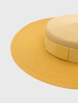 Elegant yellow Domino Racewear Boater hat with a structured silhouette and adjustable cord, designed for race day fashion.