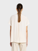 Chic double vent top in meringue color, designed for versatility and comfort in both casual and professional environments.