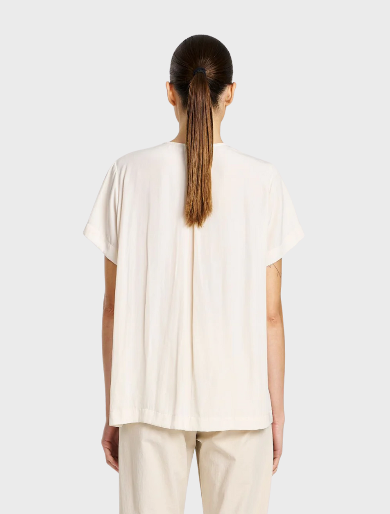 Chic double vent top in meringue color, designed for versatility and comfort in both casual and professional environments.