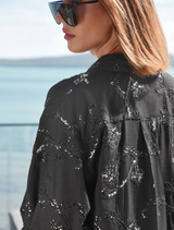 Relaxed black shirt adorned with sequins and embroidery, offering a touch of glamour with button fastenings for easy wear.