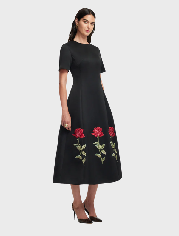 Caroline's ebony midi dress features intricate rose embellishments, ideal for adding sophistication to any wardrobe.