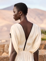 Airy ecru satin dress with V-neck and black detailing, featuring a back tie for waist adjustment and a soft modal lining.