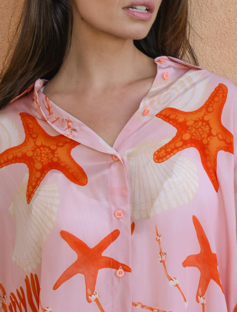 Trendy pink shell shirt featuring a creative open back design, suitable for warm weather and stylish outings.
