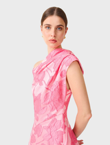 Pink floral asymmetrical maxi gown displayed on a mannequin, showcasing its elegant design and vibrant colors.