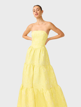 A close-up of a yellow strapless gown, highlighting its smooth fabric and stylish silhouette, perfect for evening events.