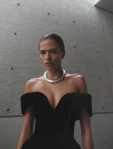 Stylish black Ryn gown laid flat, highlighting its modern cut and luxurious material.