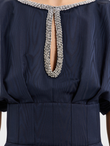  Navy sapphire gown laid flat, displaying its rich color and intricate stitching patterns.