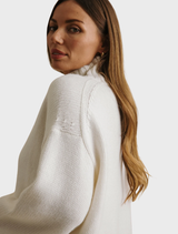 A cream Elevate Mock Merino Cashmere Pullover displayed, illustrating its elegant style and plush texture.