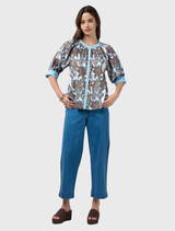 Stylish silk white multi top with button closure, shoulder shirring, and contrast print accents on cuffs and collar.