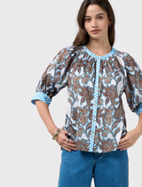 Silk white multi button-through top with shoulder shirring and contrast print on cuff, placket, and collar for added style.