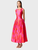 A woman models a pink and red dress, highlighting her fashionable choice in attire.