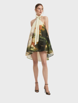 A serene pink halterneck mini dress hanging on a rack, highlighting its stylish cut and delicate fabric.