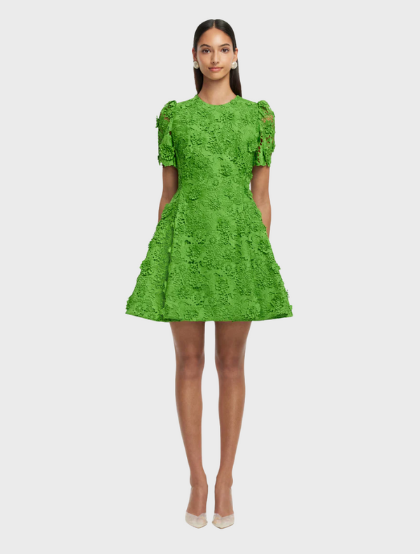 A green dress featuring a vibrant floral pattern, showcasing a blend of colors and intricate designs.