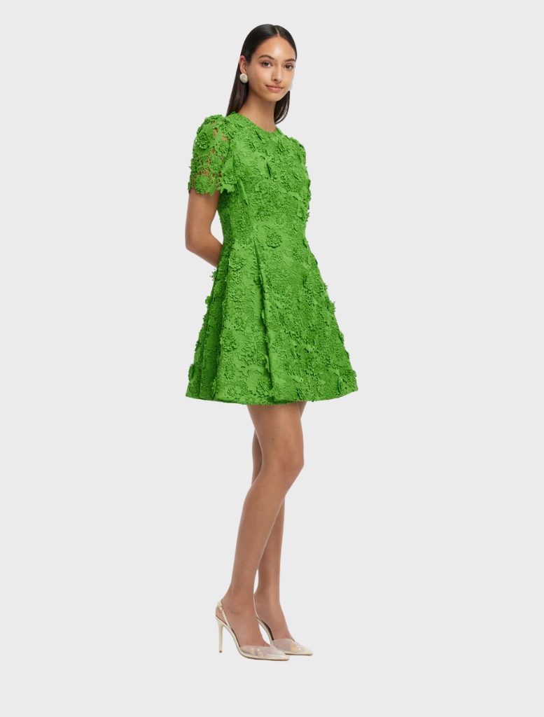 A green dress adorned with a colorful floral pattern, emphasizing its elegant and cheerful design.