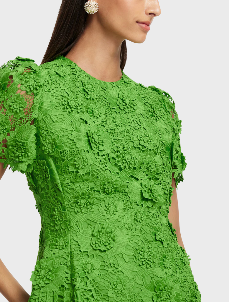 A green dress showcasing a beautiful floral pattern, combining nature-inspired elements with a fashionable silhouette.