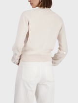 Fashionable champagne beige jacket embellished with jewelry, offering a blend of elegance and contemporary style.