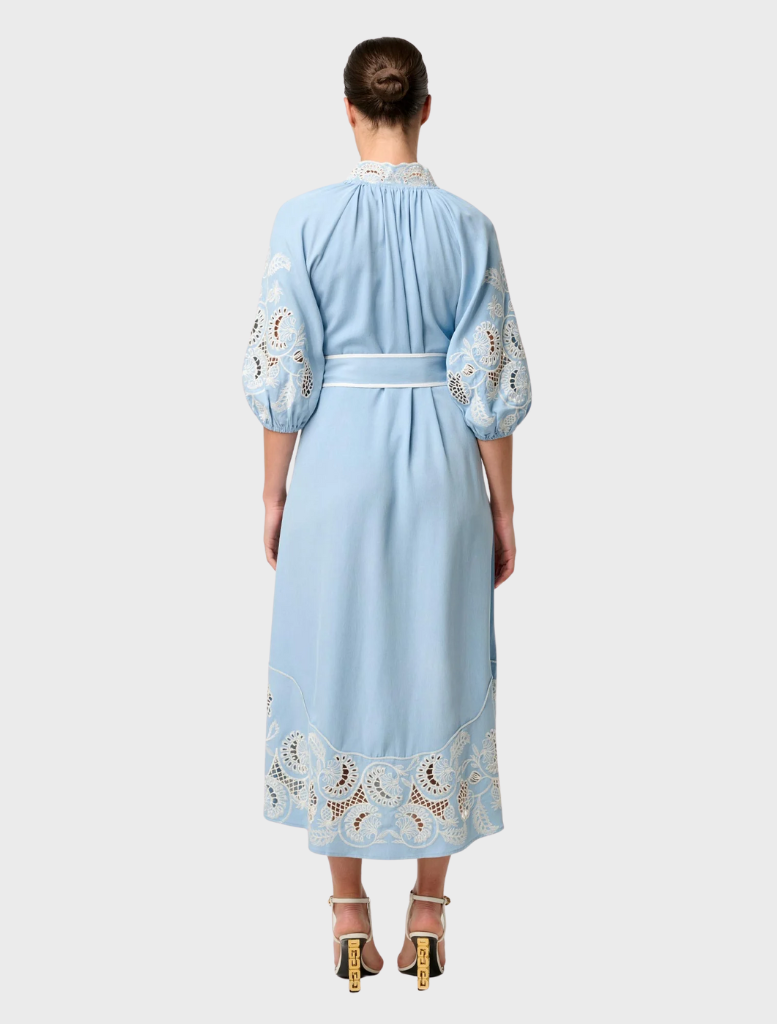 Back view of a woman in a blue maxi dress with embroidered sleeves, showcasing the Amara Tencel design in Blue Haze.