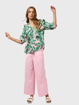 Linen top in emerald multi with a V-neck, neru collar, contrast piping, and tucks at the front highlighted by stitching.