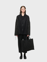 Black oversized jacket for all genders, made from a wool blend, featuring two front pockets and decorative cord accents.