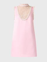 Modern rose pink shift dress with a clean silhouette, sheer neck panel, and pearl embellishments for a sophisticated look.