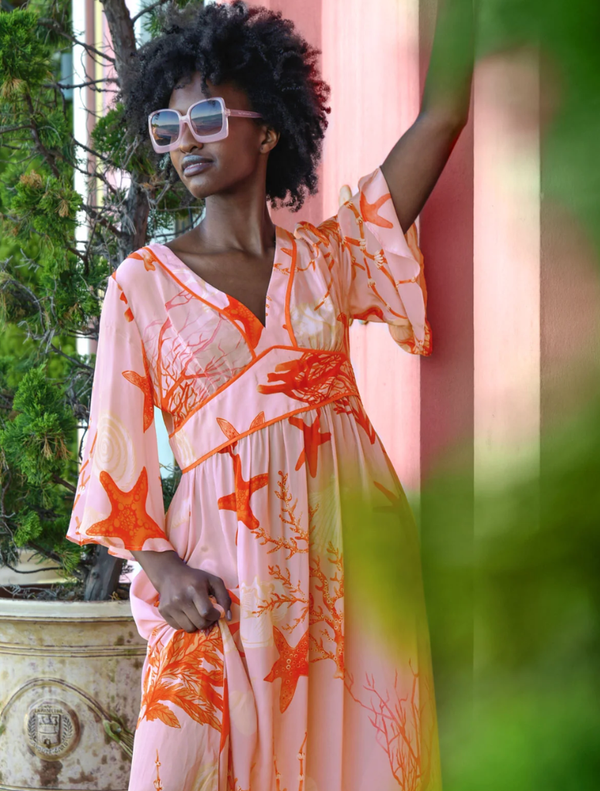 Pink shell dress with a fitted silhouette, featuring a vibrant fire-themed design, perfect for a bold fashion statement.