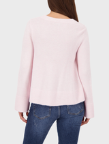 Light rose sweater with a flared design, featuring long sleeves and a soft, relaxed fit for casual wear.