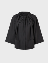 Black flip jacket displayed on a hanger, showcasing its sleek design and fabric texture.