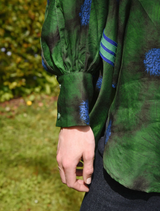 A vibrant green shirt featuring a floral pattern and the phrase "Living The Dream" in bold letters.