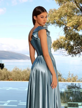A cadet blue gown hanging on a rack, featuring a sleek silhouette and delicate details.