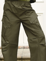 Close-up of khaki found objects pant, focusing on the fabric texture and design elements.